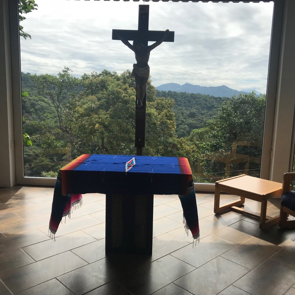 Altar and crucifix in front of chapel window