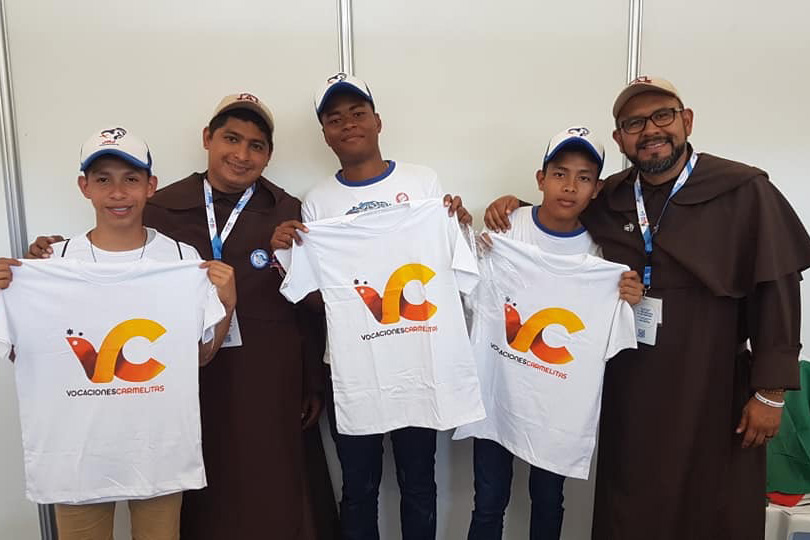 Br. Roger Melara, O. Carm., and Br. Edgar Lezama, O. Carm., join with three young men who received one of the Carmelite Youth t-shirts following their visit to the information table set up by the Carmelites.