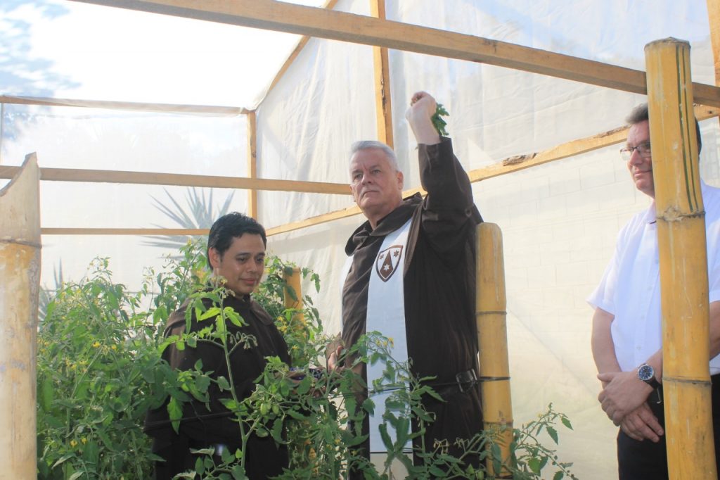 The Prior Provincial, Fr. William J. Harry, O. Carm., blesses the plants in one of the five greenhouses paid for by the German government and each being maintained by five families.
